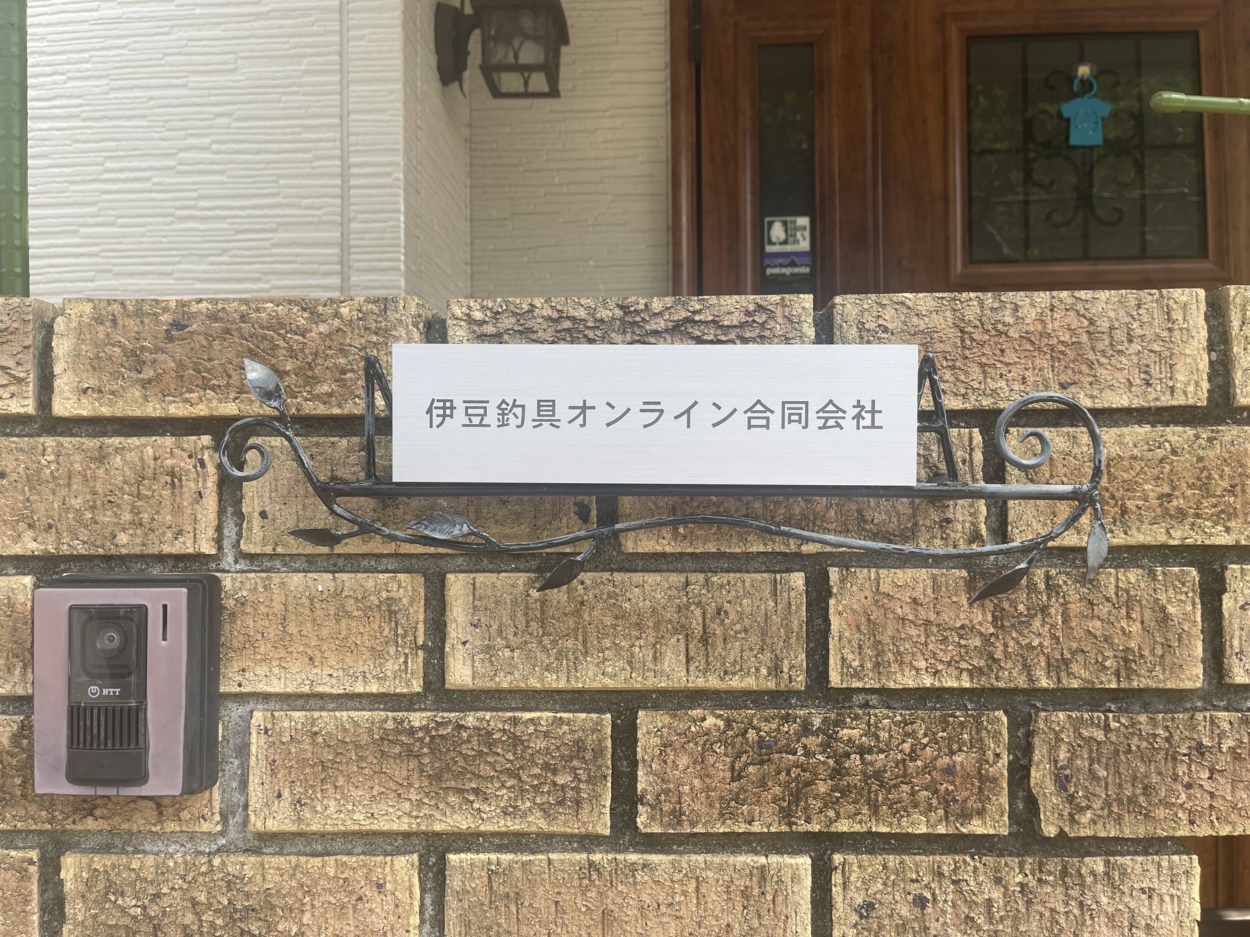 事業所入口に掲示された伊豆釣具オンライン合同会社の法人表札